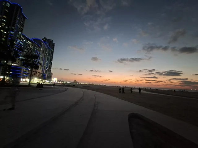 ممشى شاطئ المدينة مع ناطحات السحاب عند وقت الغروب