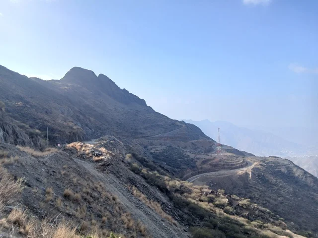 المرتفعات والقمم الجبلية بمنطقة الباحة في قرية ذي العين الأثرية جنوب المملكة العربية السعودية، منظر السماء الملبدة بالغيوم في المنطقة الجبلية، المعالم السياحية التاريخية المشهورة،  البيوت السكنية والطرقات المهيئة في المدينة، الأشجار والنباتات الخضراء