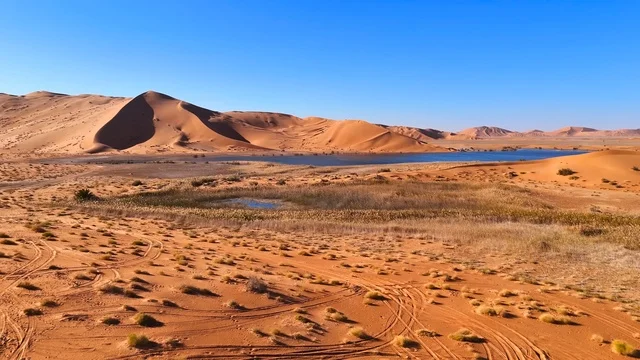 مناظر طبيعية لبحيرة وكثبان رملية في صحراء الربع الخالي