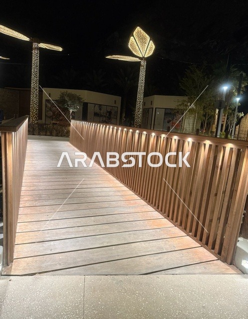 جسر مشاة خشبي في سد حتا دبي تحت إضاءة الليل