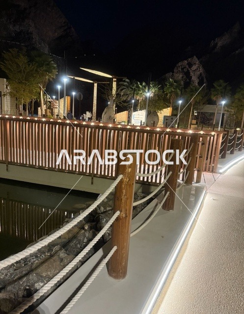 جسر خشبي مضاء في سد حتا ليلاً