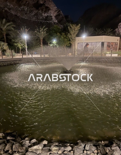 نافورة مياه طبيعية مضيئة في منطقة حتا بدبي ليلاً
