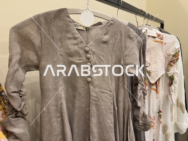 A gray patterned tunic at the Ramadan Souk event at Al-Qusaybi Hotel in the Eastern Province, a traditional Ramadan event that brings together the atmosphere of the holy month, popular shops, local products, Ramadan foods, handicrafts, and traditional gifts, in a warm cultural and social experience that reflects the spirit of Ramadan and Saudi authenticity within a luxurious hotel setting.
