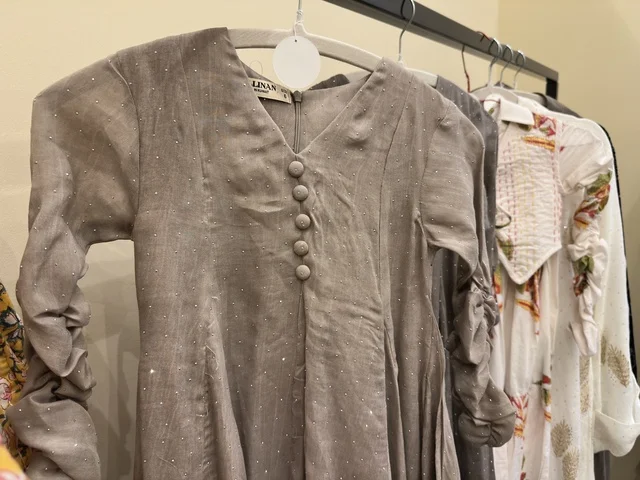 A gray patterned tunic at the Ramadan Souk event at Al-Qusaybi Hotel in the Eastern Province, a traditional Ramadan event that brings together the atmosphere of the holy month, popular shops, local products, Ramadan foods, handicrafts, and traditional gifts, in a warm cultural and social experience that reflects the spirit of Ramadan and Saudi authenticity within a luxurious hotel setting.