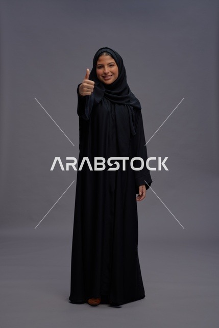 امرأة سعودية بعباءة سوداء تعطي علامة الإبهام