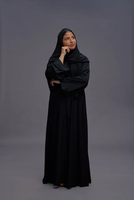 Saudi Woman in Black Abaya Thinking on Gray Background