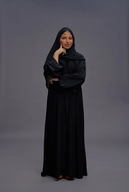 Saudi Woman in Traditional Black Abaya on Gray Background