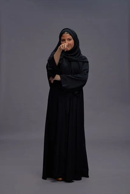 Saudi Woman in Black Abaya Gesturing in Gray Studio