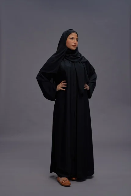 امرأة سعودية بعباءة سوداء تقليدية في استوديو