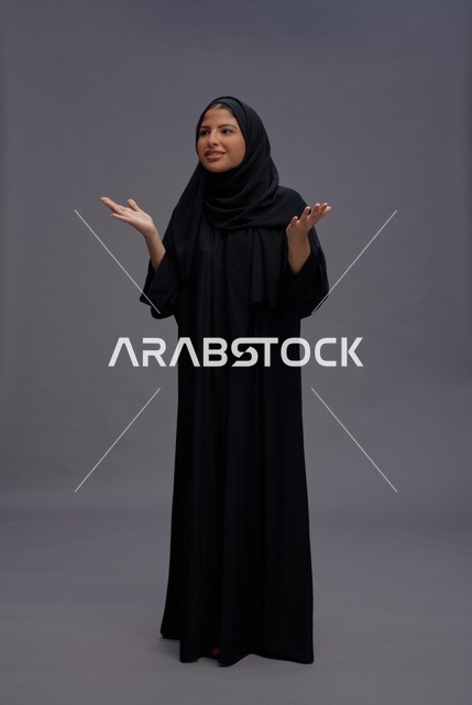 امرأة سعودية بعباءة سوداء في الاستوديو مع إيماءات