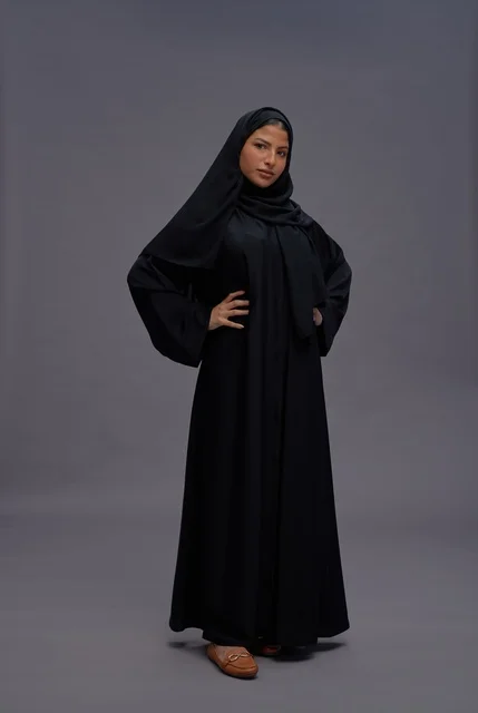 امرأة سعودية بالعباءة السوداء في استوديو تصوير