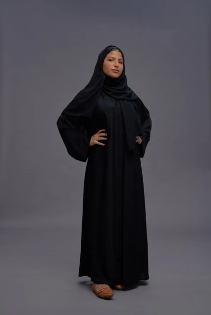 امرأة سعودية بالعباءة السوداء التقليدية في بورتريه استوديو