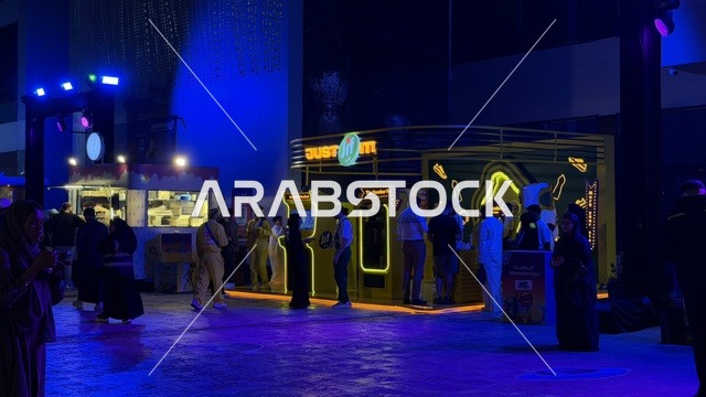 فعالية سنيكر كون جدة من 1 إلى 3 فبراير 2026 في حلبة كورنيش جدة، فعاليات موسم جدة في المملكة، أكبر معرض عالمي متخصص في ثقافة السنيكرز، منطقة تداول لبيع وشراء وتبديل الأحذية الرياضية، زوار يتجولون في جناح جيف ، آلات الألعاب الكلاسيكية ومنصات العرض في الأجواء الليلية