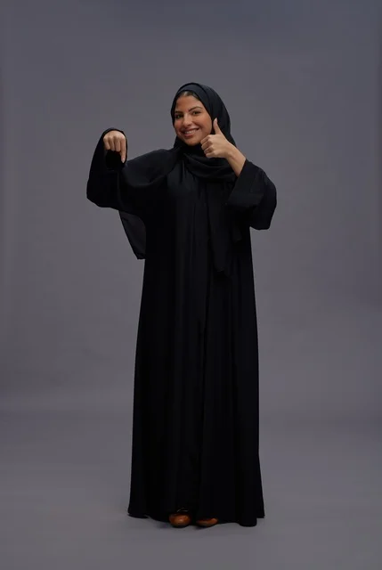 امرأة سعودية بعباءة سوداء تشير بالإعجاب وللأسفل امرأة سعودية بعباءة سوداء تشير بالإعجاب وللأسفل