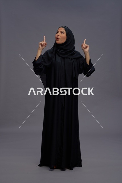 Saudi Woman in Traditional Abaya Pointing Upwards