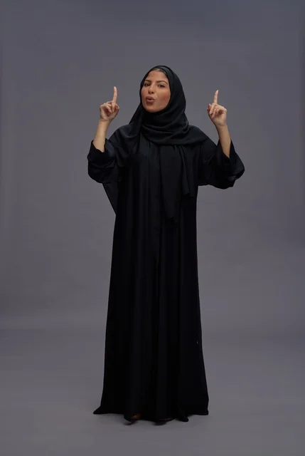 Saudi Woman in Traditional Abaya Pointing Upwards