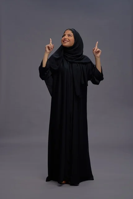 Saudi Woman in Traditional Black Abaya Pointing Up