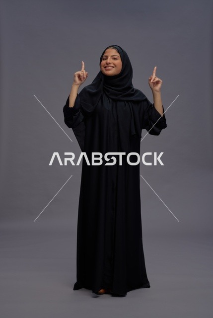 Saudi Woman in Abaya Pointing Upward in Studio