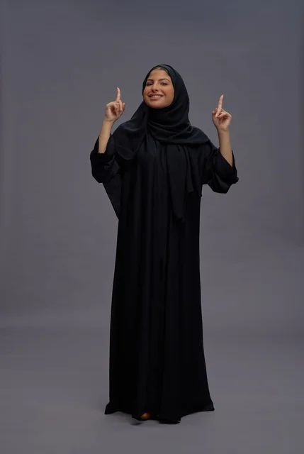 Saudi Woman in Abaya Pointing Upward in Studio