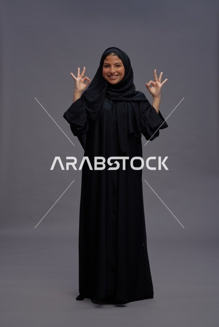 Saudi Woman in Traditional Abaya Making OK Gesture