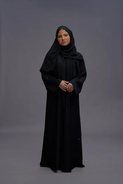 امرأة سعودية ترتدي عباءة سوداء تقليدية في الاستوديو