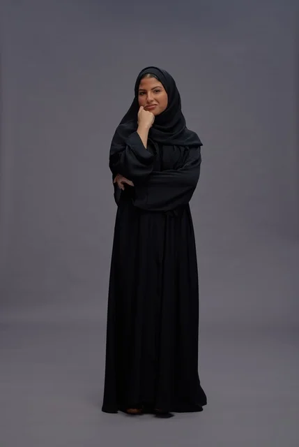 امرأة سعودية بالعباءة السوداء التقليدية في استوديو