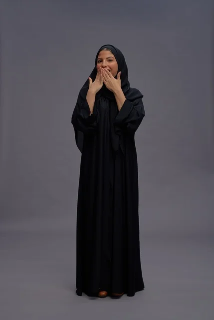 امرأة سعودية بعباءة سوداء بتعبير وجه مفاجئ