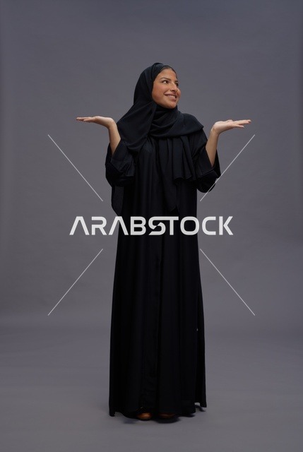 Saudi Woman in Black Abaya Presenting on Grey Background