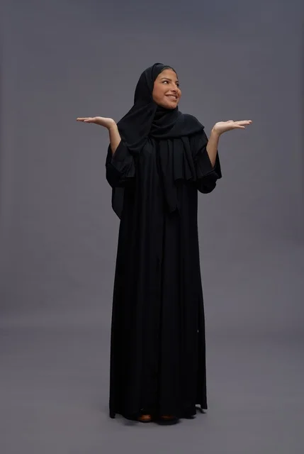 Saudi Woman in Black Abaya Presenting on Grey Background