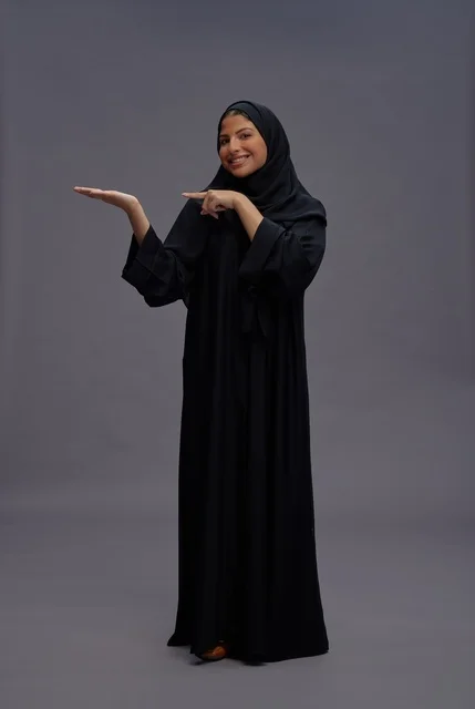 امرأة سعودية بعباءة سوداء تشير بيدها