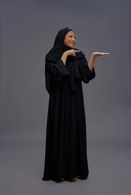 Saudi Woman in Black Abaya Presenting on Gray Background