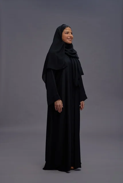 امرأة سعودية بالعباءة السوداء التقليدية في استوديو