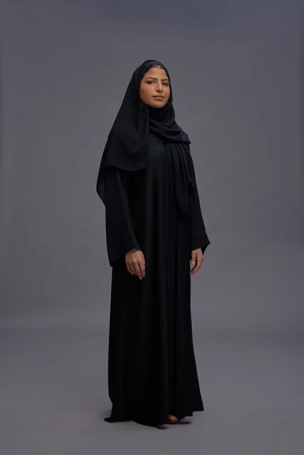امرأة سعودية بالعباءة السوداء التقليدية في استوديو