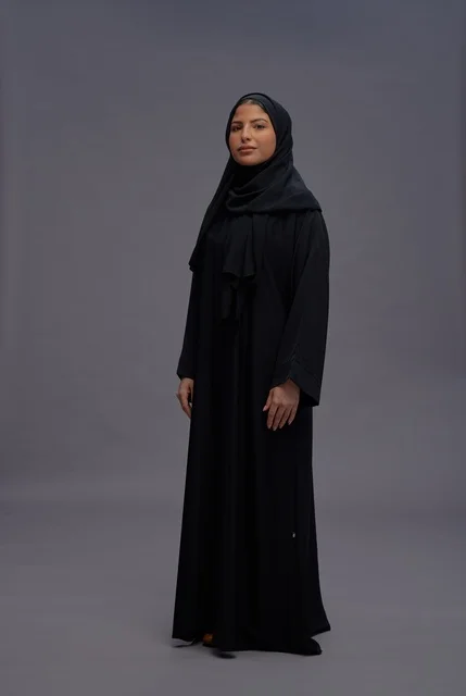 امرأة سعودية بالعباءة السوداء التقليدية في الاستوديو