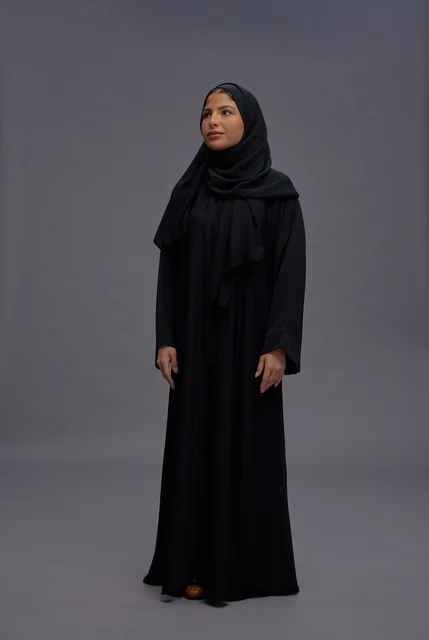 امرأة سعودية بعباءة سوداء تقليدية في الاستوديو