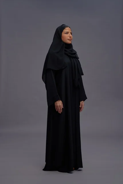امرأة سعودية بالعباءة السوداء التقليدية في استوديو