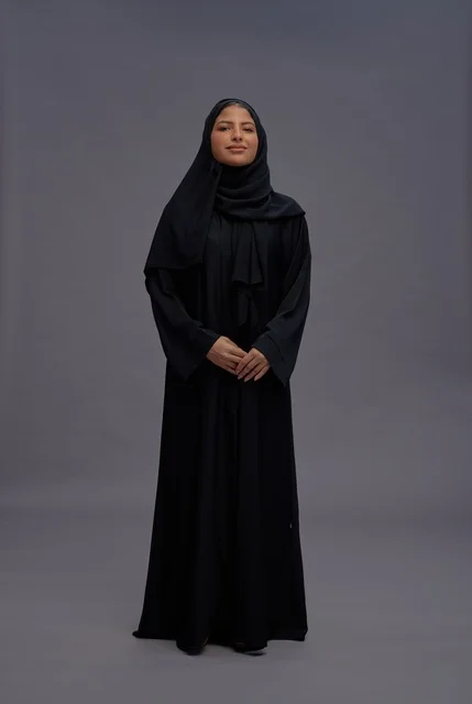 امرأة سعودية بعباءة سوداء تقليدية في استوديو