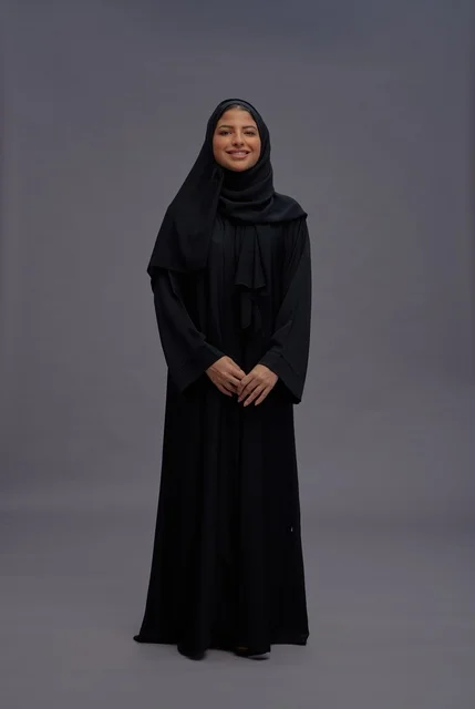 امرأة سعودية بالعباءة السوداء التقليدية في استوديو