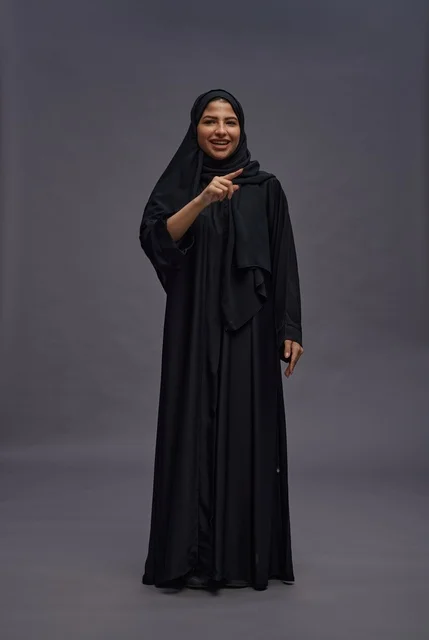 Saudi Woman in Traditional Black Abaya Pointing at Camera