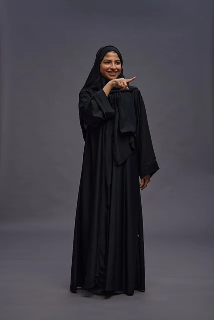 Saudi Woman in Black Abaya Pointing to Side in Studio