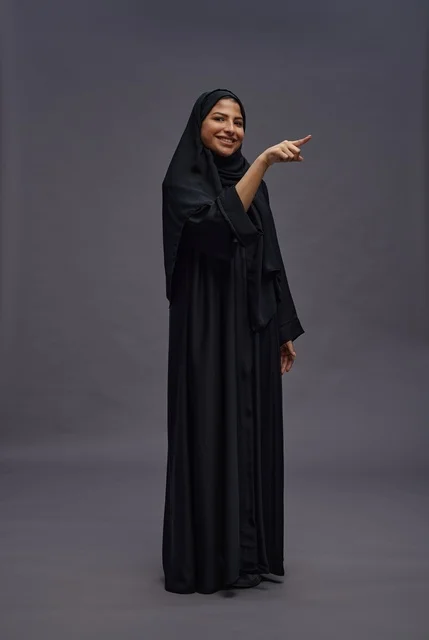 Saudi Woman in Black Abaya Pointing in Studio Portrait