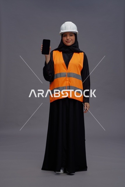 Arab Female Engineer in Safety Vest Holding Smartphone