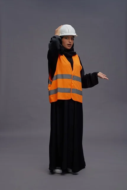 مهندسة سعودية ترتدي سترة السلامة وخوذة العمل