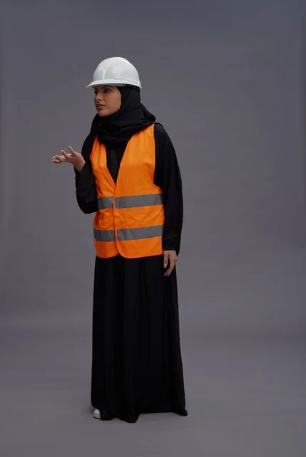 مهندسة سعودية ترتدي سترة سلامة وخوذة في استوديو