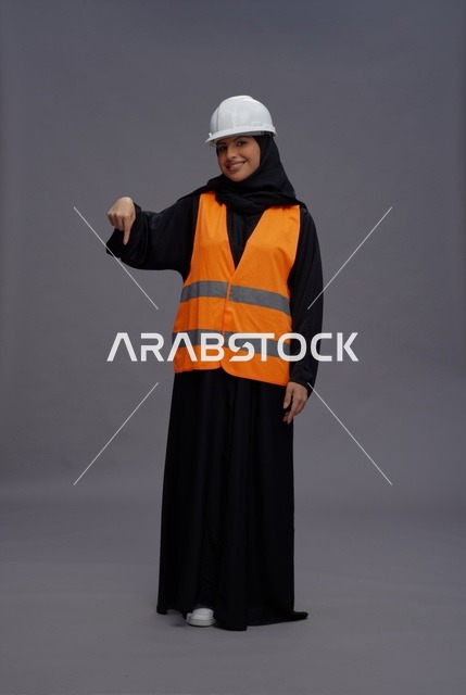 مهندسة سعودية بزي السلامة تشير إلى الأسفل