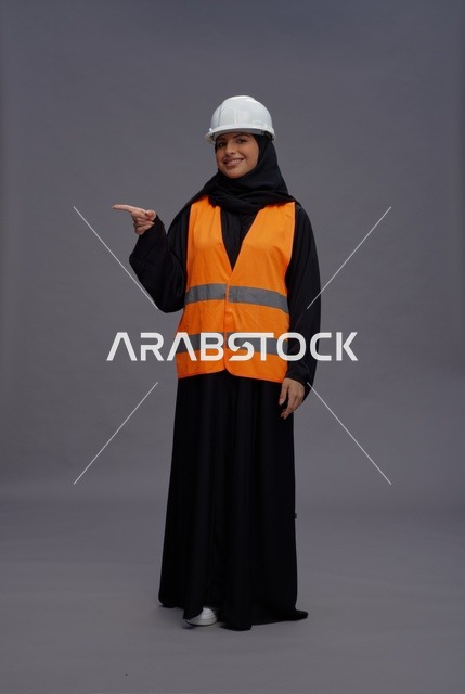Saudi Woman Engineer Pointing Sideways in Safety Gear