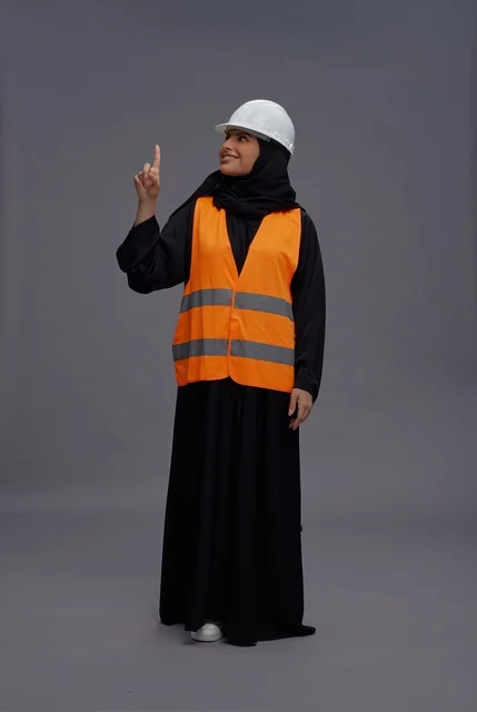 مهندسة سعودية بملابس السلامة تشير إلى الأعلى