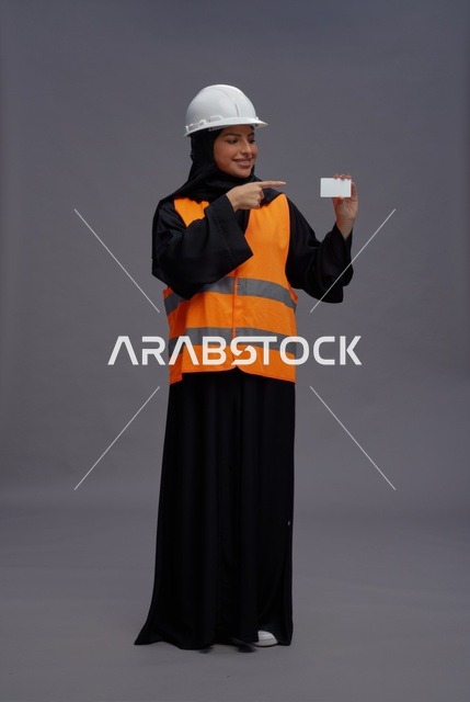 مهندسة سعودية تحمل بطاقة عمل فارغة بملابس العمل