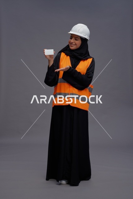 مهندسة سعودية تمسك ببطاقة عمل فارغة