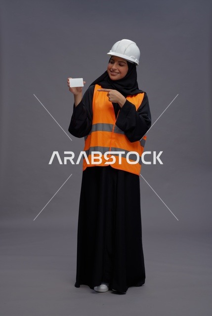 مهندسة عربية تحمل بطاقة عمل بيضاء فارغة